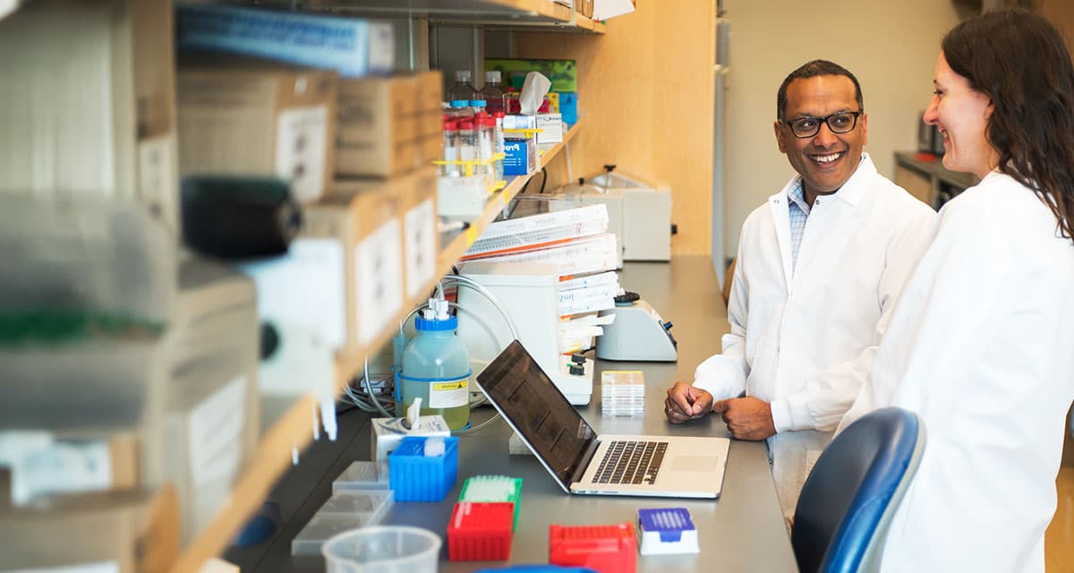 Dr. Sid Rao in his lab having a conversation with a team member.