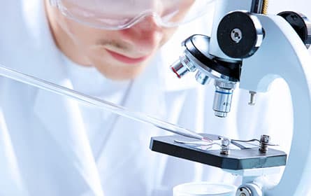 Researcher loading sample on microscope slide.