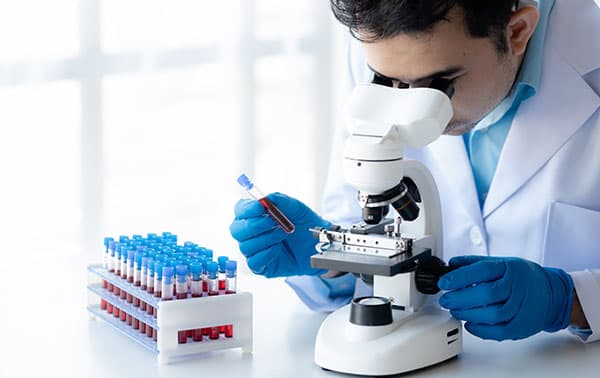 Researcher looking through a microscope