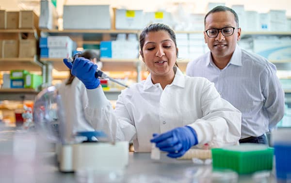 Dr Rao and research technician pipetting samples.