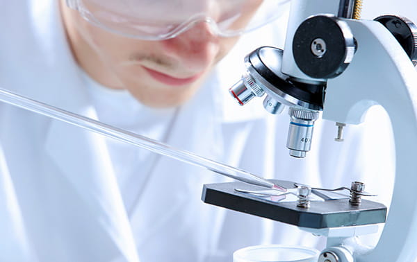 Researcher loading a sample on a microscope slide.