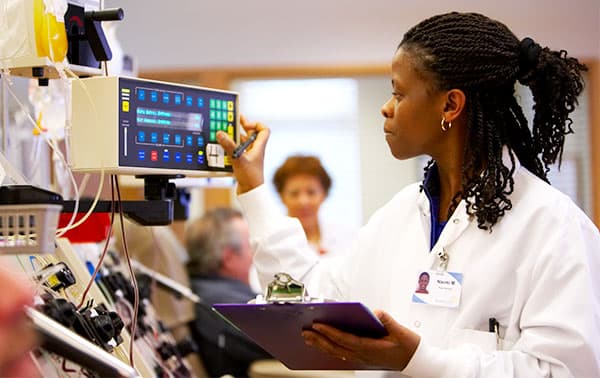 Phlebotomist looking at an apheresis machine.