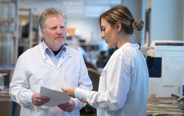Dr. Curtis speaking with a lab technician.