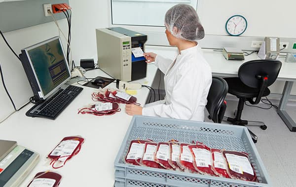 Technician labeling blood units.