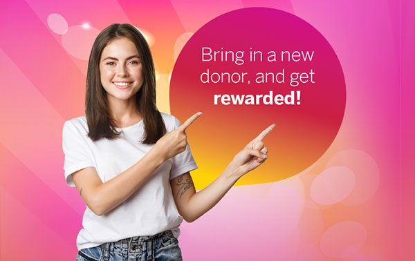 Smiling woman pointing. Bring a new donor and receive a $20 reward.