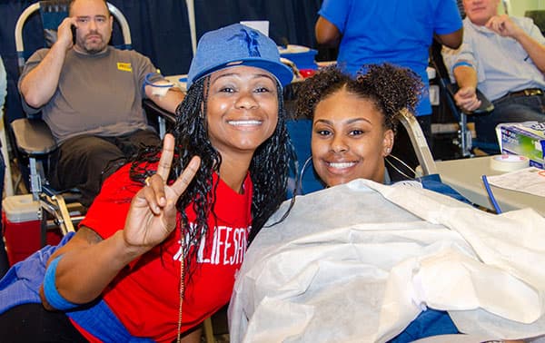 Smiling blood donors at an annual Bleed Blue blood drive.