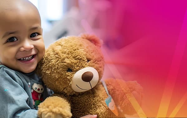 A little boy holding a stuffed teddy bear.