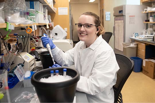 Lab technician smiling while working on some samples.