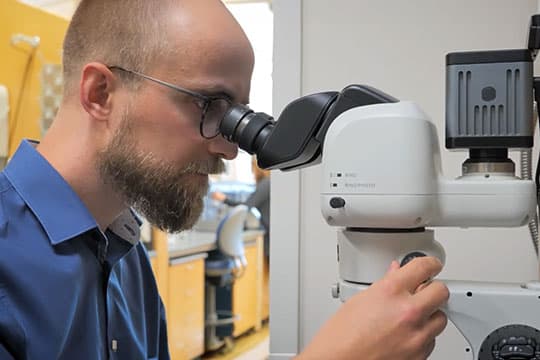 Dr. Sugden using a powerful microscope.