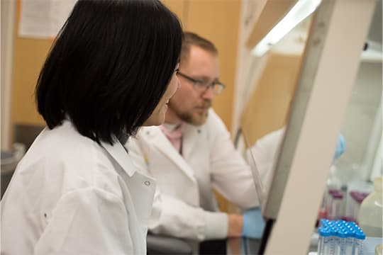 Two trainees working at a bench conducting tests.