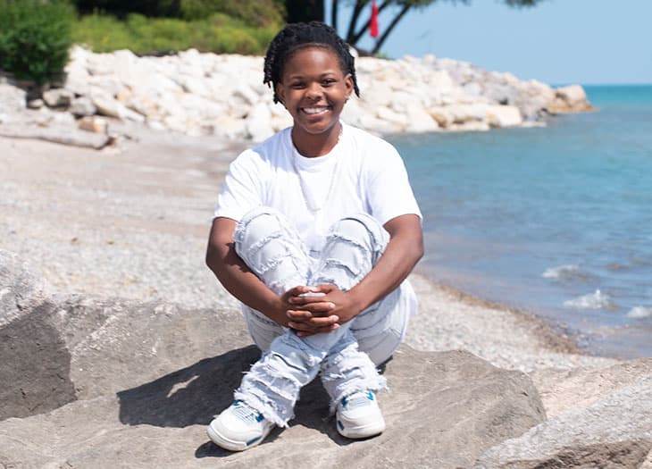 Tia Wilson, sitting on a rock on the beach.