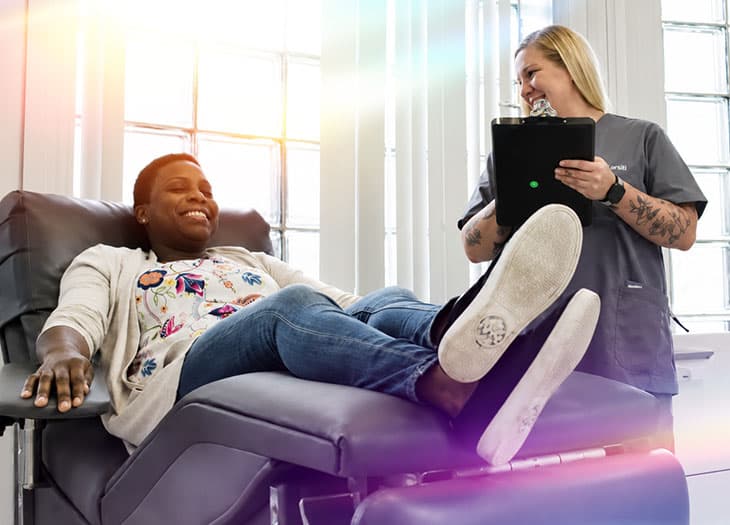 An african american woman sitting in a chair making her donation.