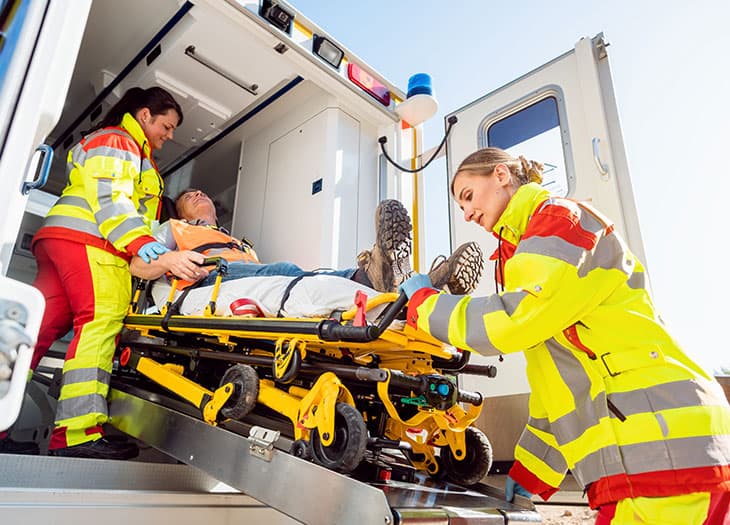 EMT's helping an accident victim into an ambulance.