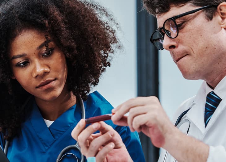 Nurse talking about a blood sample with a doctor.